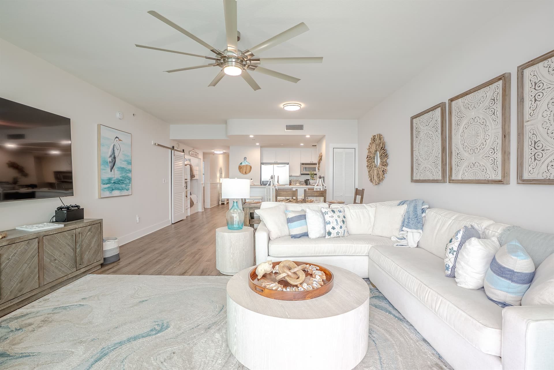 Spacious living area with large sectional and open kitchen behind
